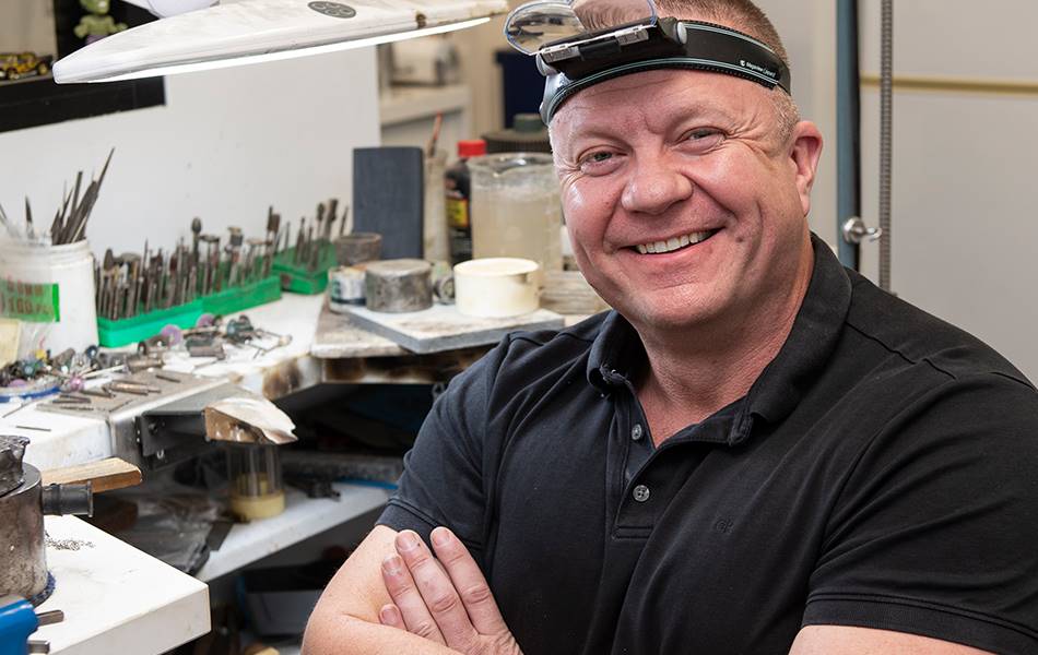 Troy O’Brien of Troy O’Brien Jewellery next to his workspace.