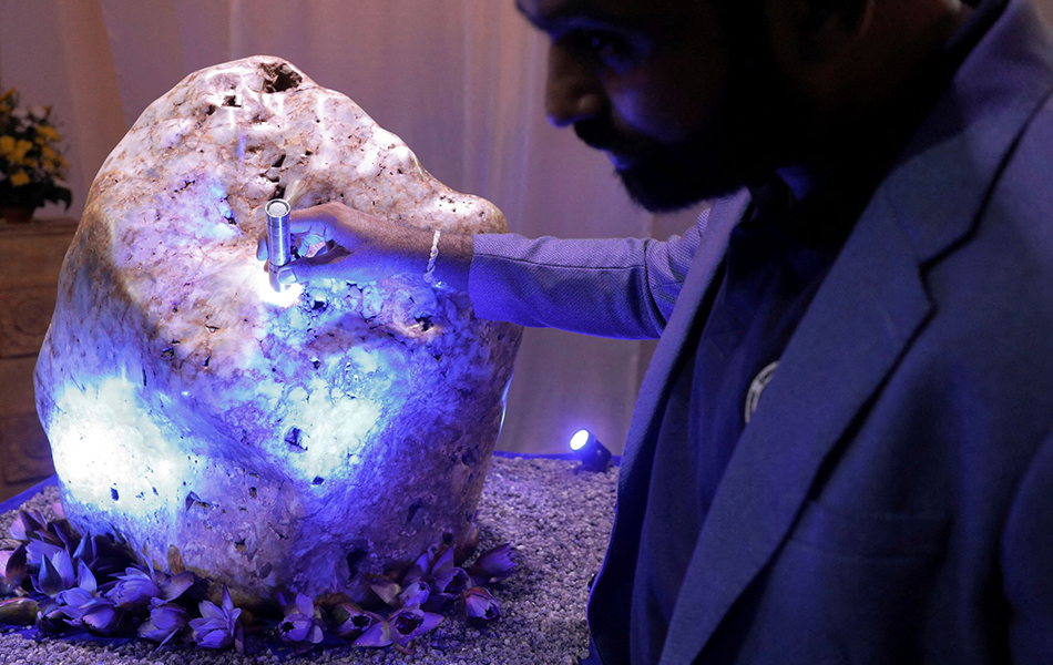 Gemological Institute of Ratnapura director Chamila Suranga inspects the 310kg corundum. <b>Image:</b> Reuters – Dinuka Liyanawatte