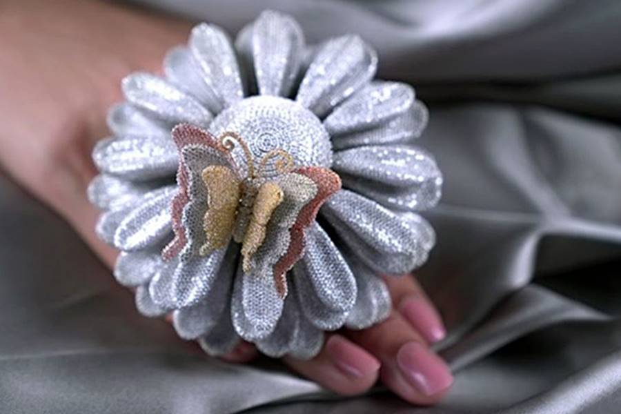 The piece is inspired by a sunflower, with the manufacturing process taking approximately nine months from design to completion. The ring features eight distinct parts including four layers of petals, the shank, two diamond discs, and a butterfly. | Source: Rocky Point Jewelers