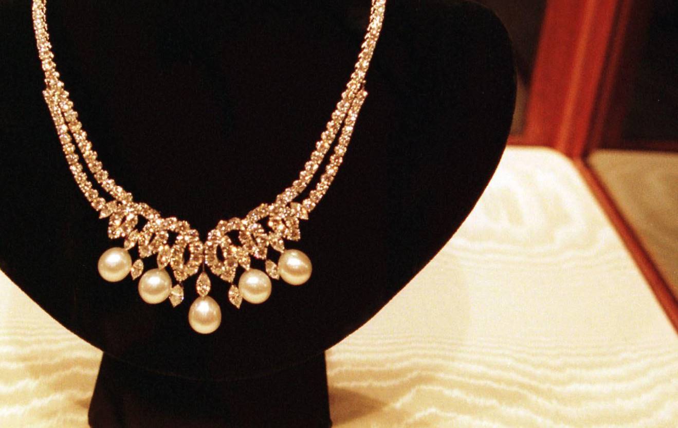 The platinum necklace is mounted with brilliant-cut diamonds in a scroll motif. Suspended from the necklace are five cultured South Sea pearls and seven marquise diamonds. | Source: Gettyimages