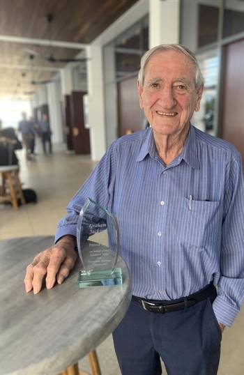 Graham Jackson stands with an award to recognise his contribution to the Salvation Army. 