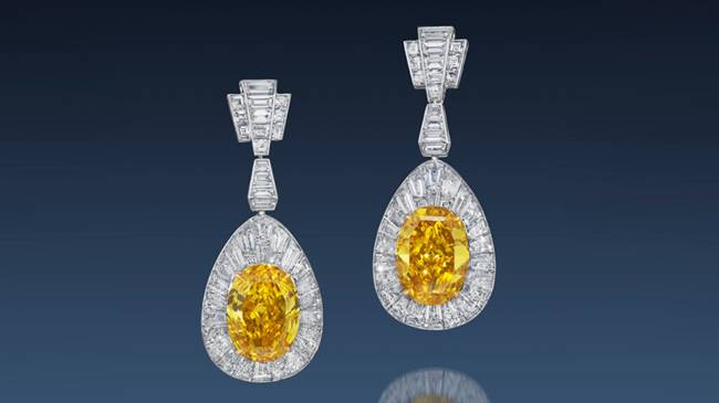 The Oriental Sunrise earrings feature two oval mixed-cut fancy vivid orange yellow diamonds.