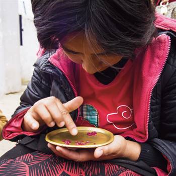 A woman sorts stones in Mogok’s market